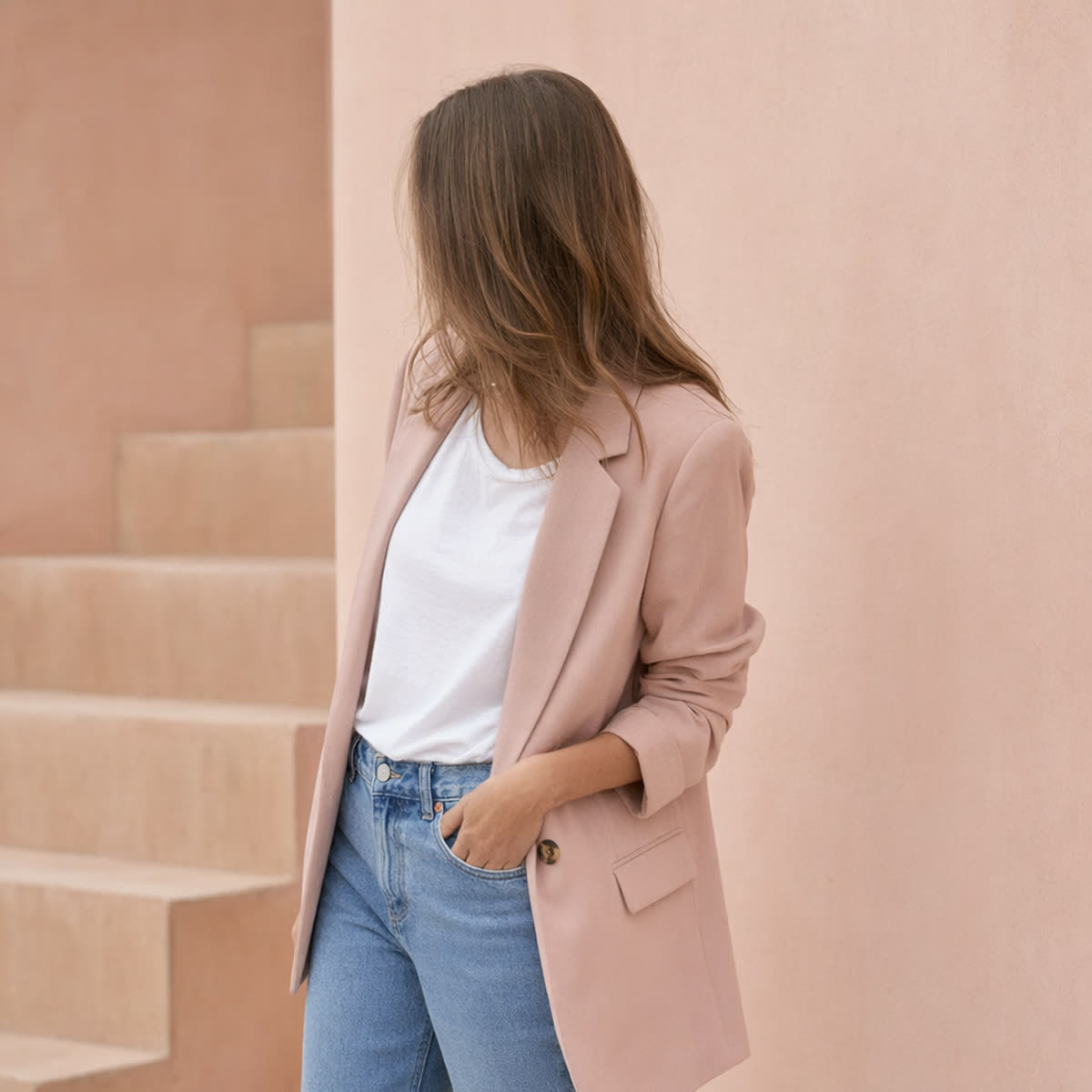 A woman wearing a blazer over a white tee with blue jeans — casual blazer styling